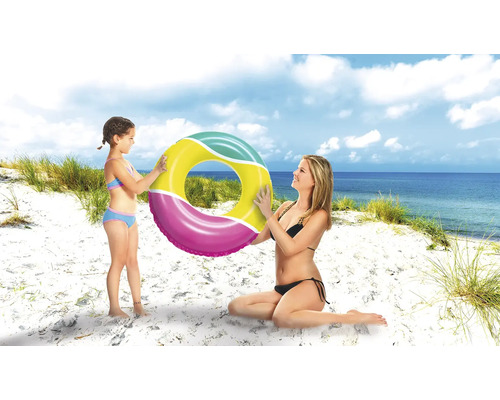 Mutter und Tochter halten einen Schwimmring am Strand