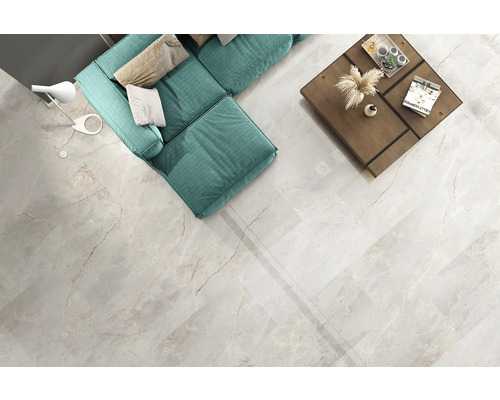 Heller Wohnraum mit Sofa, Tisch und Bodenfliesen in Marmoroptik