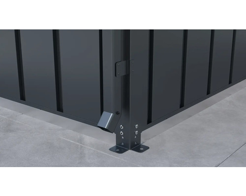Detailansicht einer Metallzaun-Ecke mit Regenablauf und Bodenbefestigung
