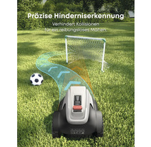 Ein Rasenmähroboter umfährt auf einer Rasenfläche ein Fußballtor und einen Fußball.