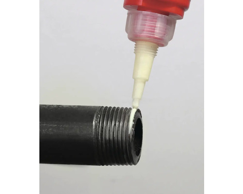 Eine Dichtungsmasse wird auf das Gewinde eines schwarzen Rohres aufgetragen.