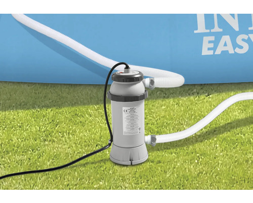 Intex Filterpumpe mit Schläuchen auf Rasen vor einem Pool