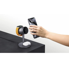 Ladestation mit Smartwatch, Ohrhörern und Smartphone auf einer Oberfläche