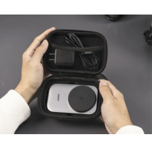 Person hält offenes Aukey-Ladegerät-Etui mit Ladegerät, Kabel und drahtloser Ladestation