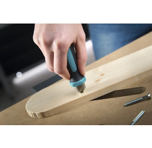 Eine Hand senkt einen Senker der Marke Wolfcraft in ein Holzbrett, um eine Schraube zu versenken.