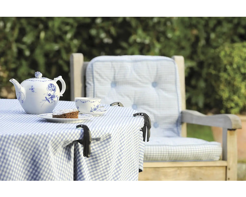 Gedeckter Gartentisch mit Teekanne, Tasse und Kuchen auf einer Terrasse mit Stuhl