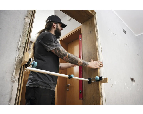 Mann montiert eine Türzarge mit einem Montagewerkzeug