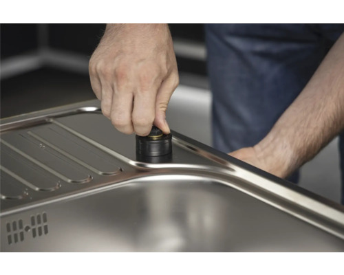 Detailaufnahme eines Handabflusssystems aus Metall in einer Spüle