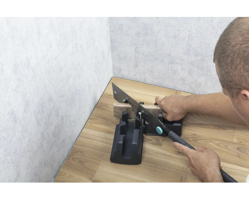 Handsäge mit Schneidlade beim Sägen eines Holzstücks