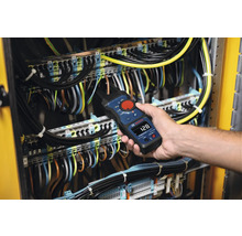 Eine Person verwendet eine Strommesszange von Bosch an einer elektrischen Anlage.