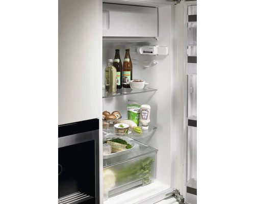 Innenraum eines Kühlschranks mit Lebensmitteln auf Glasregalen und in Schubladen