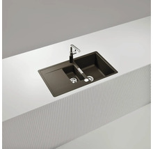 Spüle aus Verbundmaterial mit Abtropffläche und Armatur auf einer Arbeitsplatte