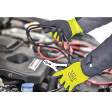 Überbrückungskabel wird mit Arbeitshandschuhen an Autobatterie angeschlossen