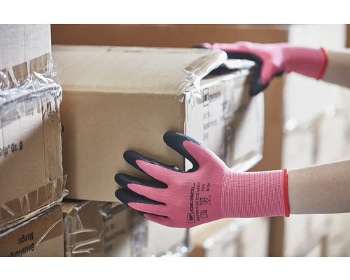 Frau mit Arbeitshandschuhen beim Tragen eines Kartons