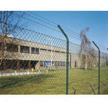 Drahtzaun mit Stacheldraht vor einem Gebäude