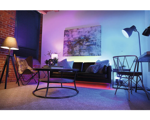 Wohnzimmer mit Sofa, Couchtisch, Stehlampe und Kunst an der Wand