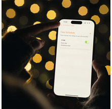 Smartphone mit geöffneter App zur Steuerung von Weihnachtslichtern