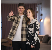 Ein Paar steht in einem Raum mit Vorhängen und Beleuchtung.