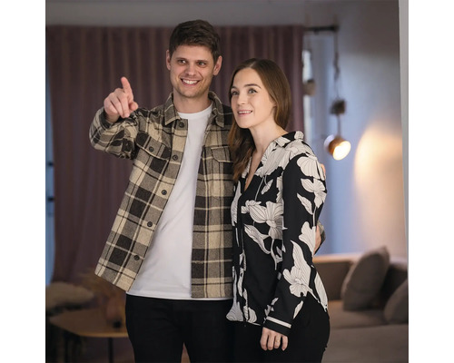 Ein Paar steht in einem Raum mit Vorhängen und Beleuchtung.