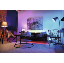 Wohnzimmer mit Sofa, Tisch, Stuhl, Stehlampe und Wandkunst für eine atmosphärische Raumgestaltung