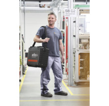 Mann trägt Werkzeugkoffer von Wiha in einer Produktionshalle