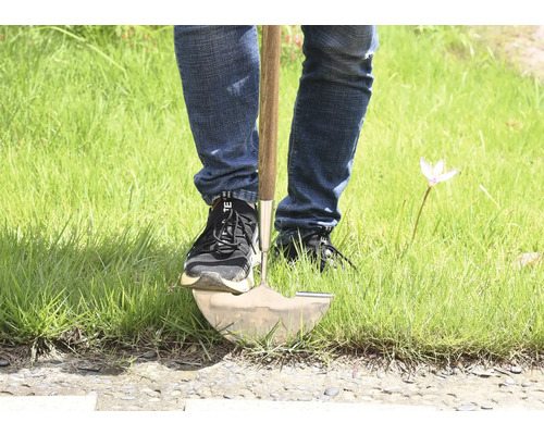 Person, die einen Spaten im Gras benutzt.