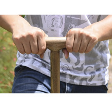 Nahaufnahme einer Person, die einen Spatenstiel mit Holzgriff hält