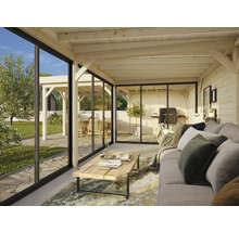 Wohnraum mit Schiebetüren, Holzdecke, Sofa und Gartenausblick