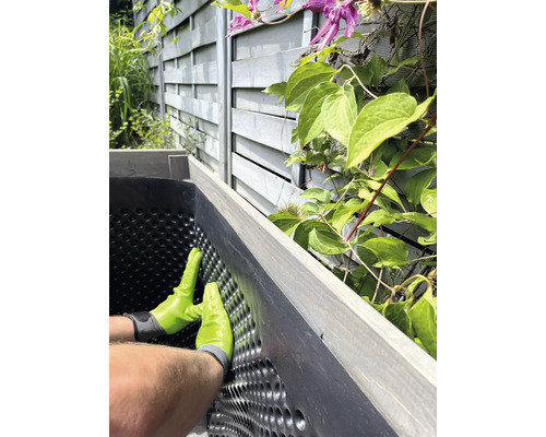 Einbau einer Noppenbahn in einen Pflanzkasten im Garten.