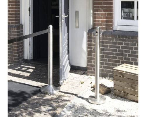 Absperrpfosten aus Edelstahl mit Gurt vor Gebäude