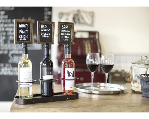 Arrangement mit Weißwein, Rotwein und Roséwein mit zugehörigen Tafeln in einer Bar