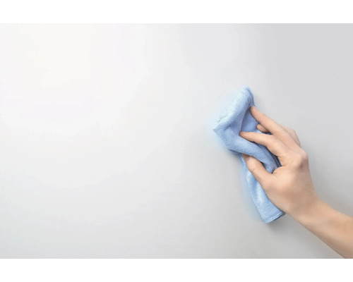 Hand wischt mit Reinigungstuch eine Oberfläche