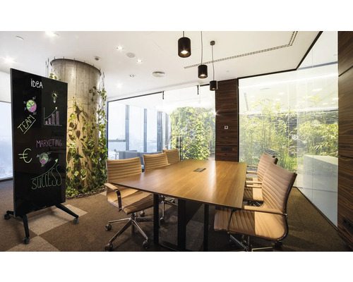Konferenzraum mit einem Holztisch, Bürostühlen und einer mobilen Whiteboard Tafel mit Ideen Skizzen