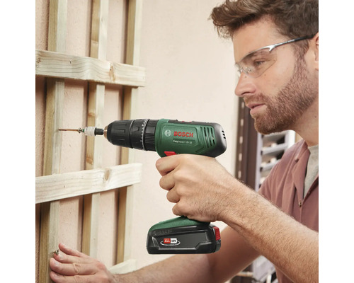 Mann schraubt mit einem Bosch Akku-Schlagschrauber ein Holzbrett fest
