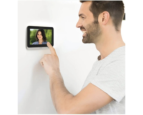 Ein Mann bedient eine Türsprechanlage mit Display.