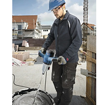 Handwerker verwendet einen Mörtelrührer von Bosch zum Mischen von Putz auf einer Baustelle.