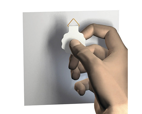 Hand befestigt einen Bilderhaken an der Wand