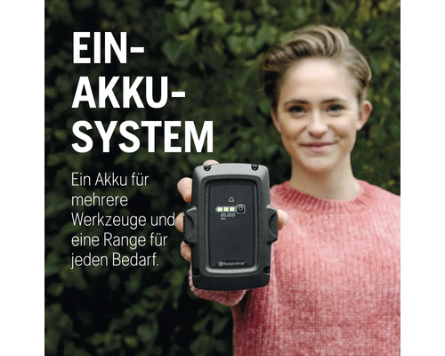 Frau hält Husqvarna Akku BLi20 in die Kamera