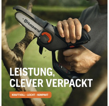 Eine Person schneidet einen Ast mit einer Akku-Kettensäge von Husqvarna.