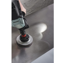 Eine Bohrmaschine mit einem Schleifaufsatz wird auf einer Metalloberfläche verwendet.
