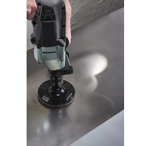 Eine Schleifmaschine mit Schleifscheibe wird auf einer Metalloberfläche verwendet.