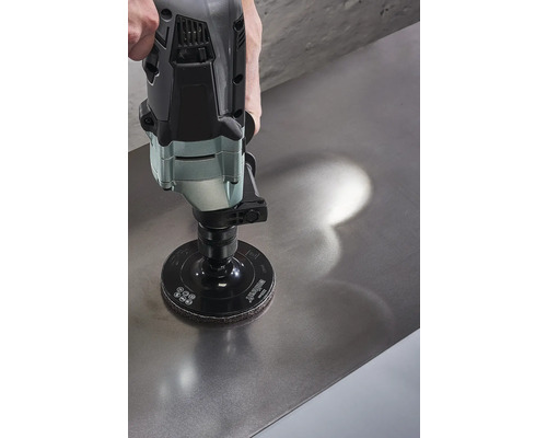 Eine Schleifmaschine mit Schleifscheibe wird auf einer Metalloberfläche verwendet.