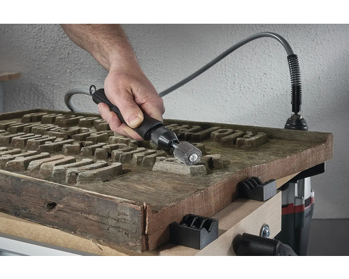 Mann verwendet eine biegsame Welle an einem Werkstück aus Holz