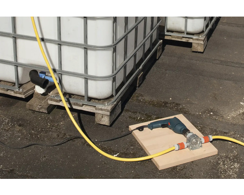 Szene mit IBC-Containern, einer Bohrmaschine und einer Schlauchpumpe auf einem Brett.
