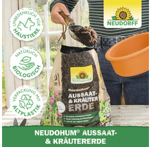 Eine Person füllt Aussaat- und Kräutererde von Neudorff mit einer Schaufel in einen Pflanztopf. Auf der Verpackung sind die Logos für tierfreundlich, biologisch und Recyclingkunststoff abgebildet.