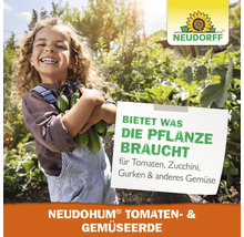 Glückliches Kind mit Gurkenernte im Gemüsegarten, Neudorff Logo, Hinweis auf Neudohum Tomaten- und Gemüseerde