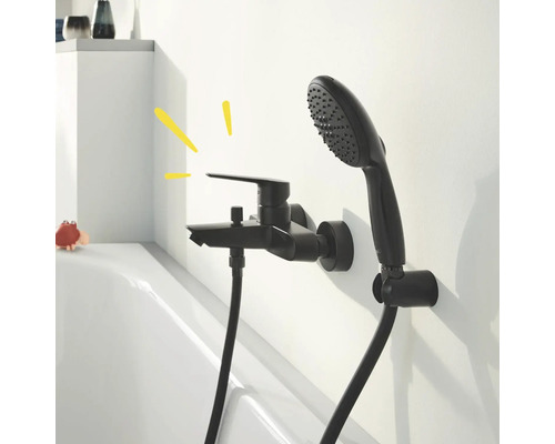 Schwarze Badewannenarmatur mit Handbrause an weißer Wand montiert