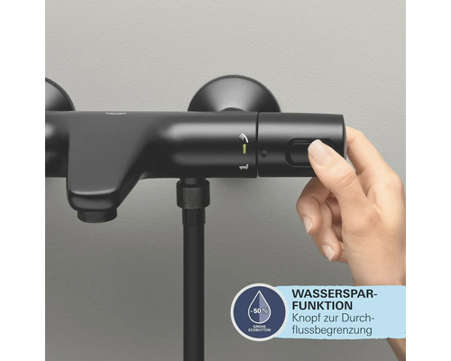 Schwarze Duscharmatur mit Wassersparfunktion und Hand, die einen Knopf drückt