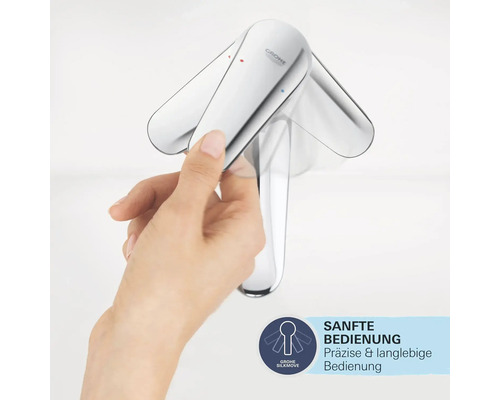 Hand betätigt eine glänzende Armatur mit Grohe SilkMove Technologie für sanfte Bedienung