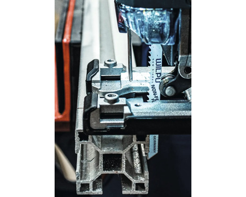 Detailansicht einer Stichsäge beim Schneiden eines Metallprofils.